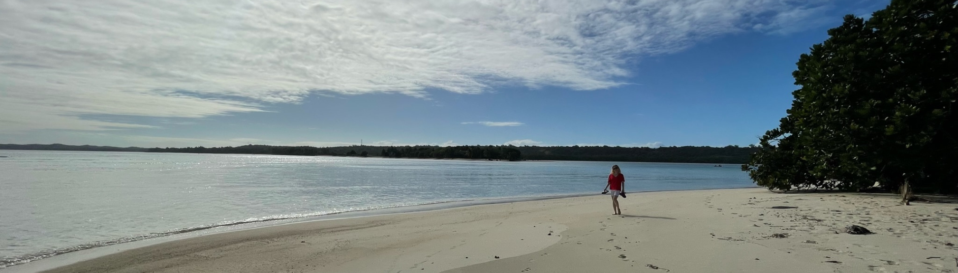 A woman walking the beach at Ile aux Nattes