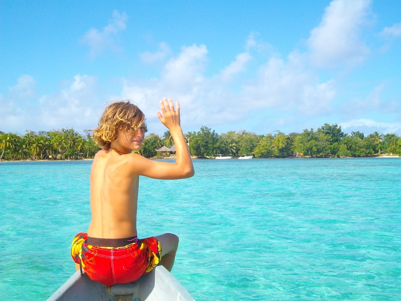 A boy sailing a pirouge in from of Aurora Lodge